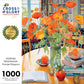 Garden Puzzle – Poppies Panorama: Orange Elegance – 1000 Piece Jigsaw Puzzle featuring beautiful artwork of vibrant orange poppies in a glass vase on a table with books, premium quality, satin finish, dust free, eco-friendly 1000 piece jigsaw puzzles for adults.